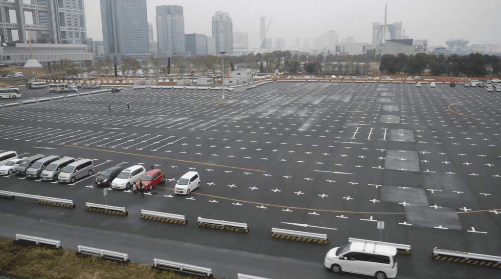 a parking lot with cars and buildings in the background