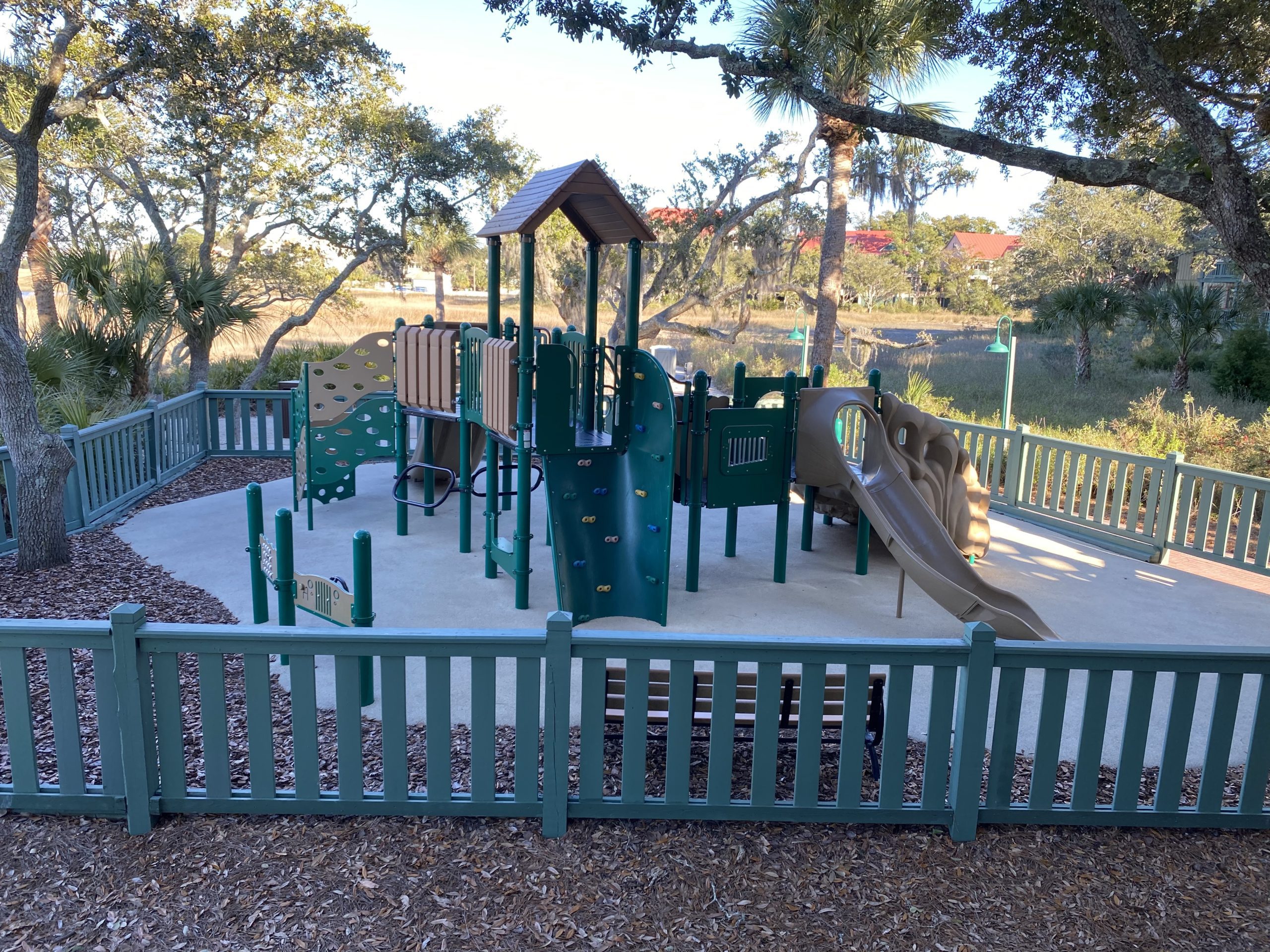 a playground with a fence and trees