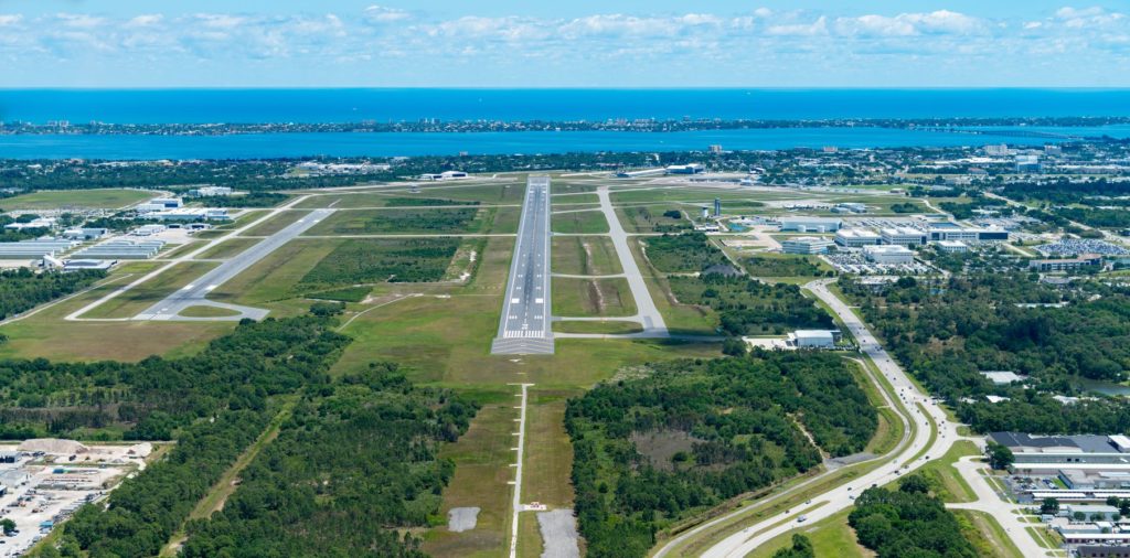 an aerial view of a runway and a body of water