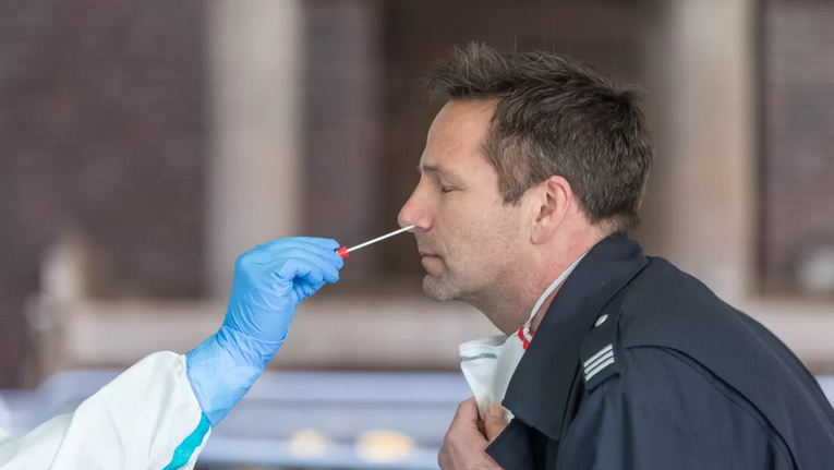 a person holding a swab to a man's nose