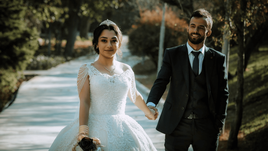 a man and woman in wedding attire holding hands