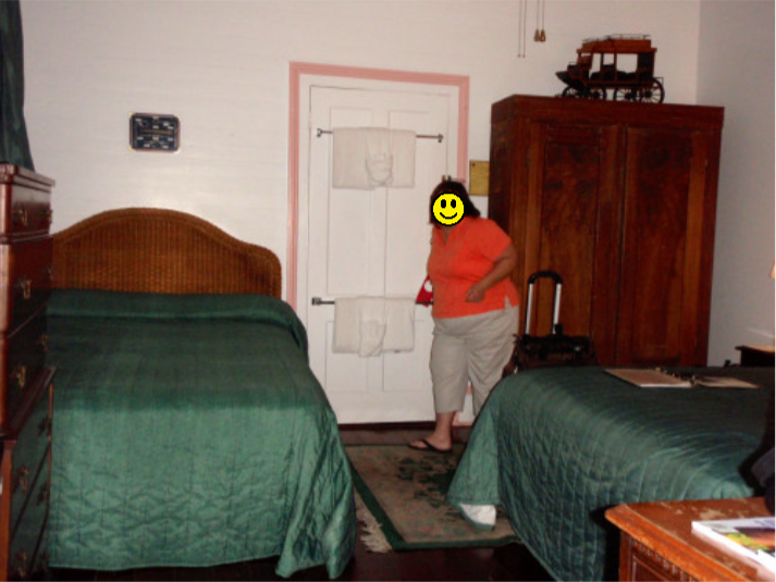 a woman standing in a room with two beds