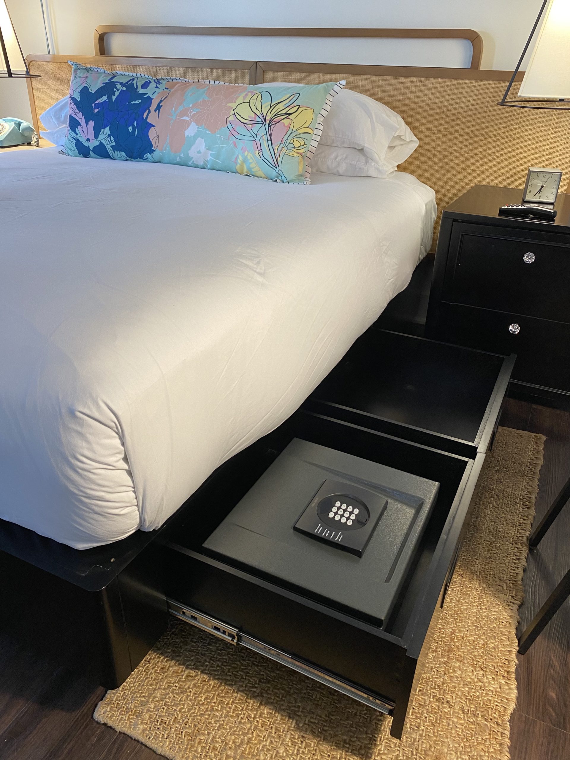 a bed with a small black drawer