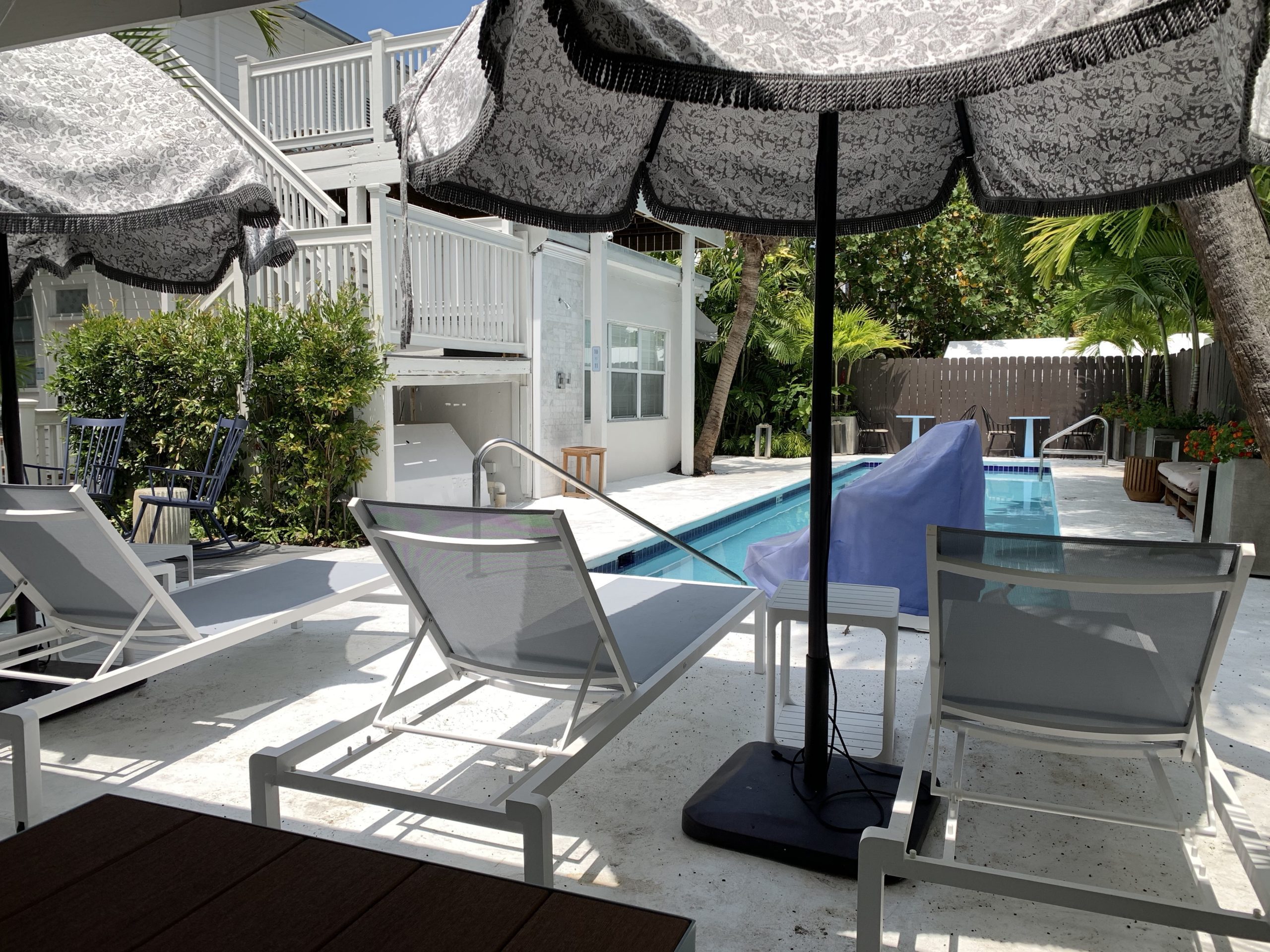 a pool with a deck chair and umbrella
