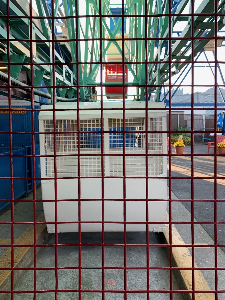 a cage with a metal grid behind it