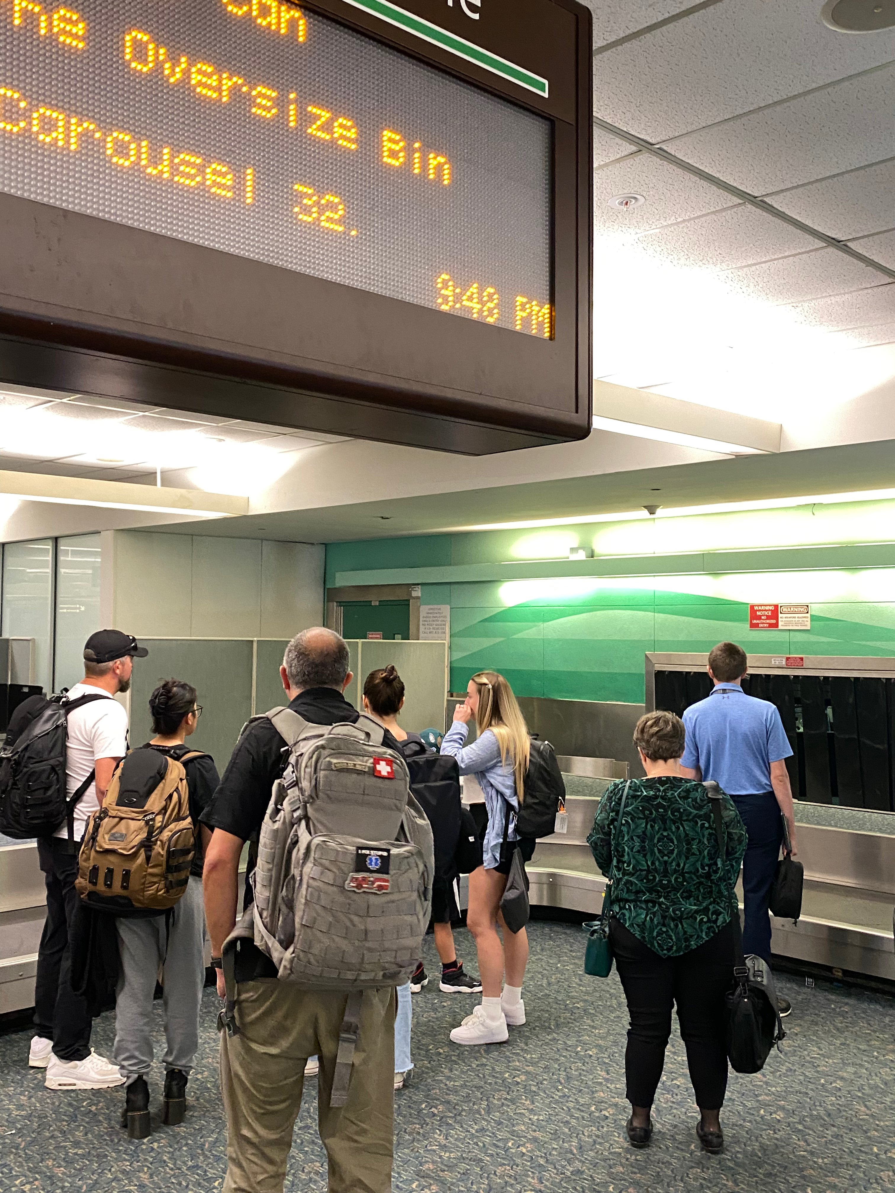 a group of people standing in a room with a digital sign