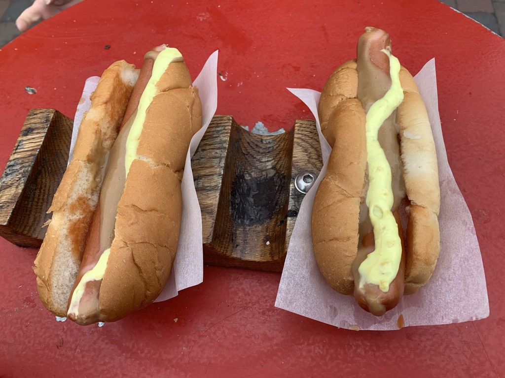 a group of hot dogs on paper on a red table