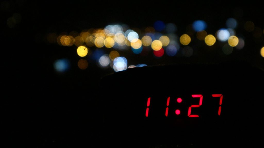 a digital clock with lights in the background