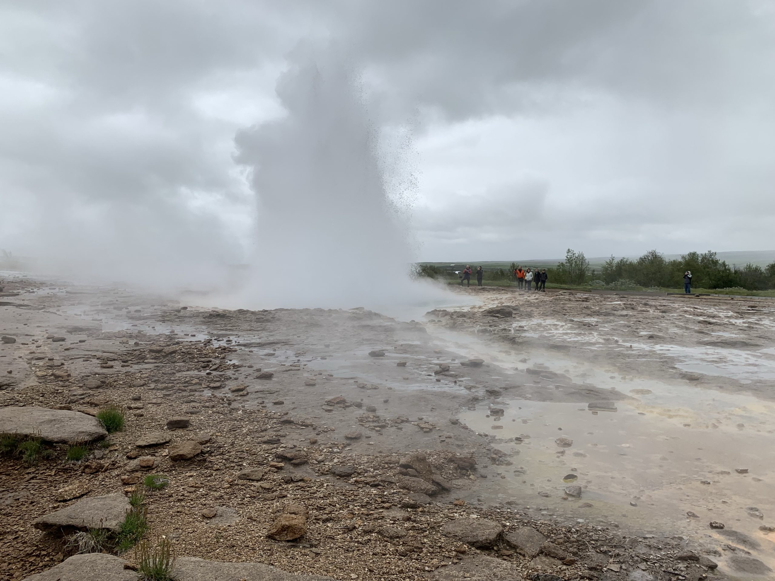 a geyser erupting in a rocky area