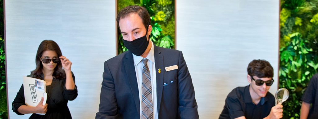 a man in a suit and tie wearing a black face mask