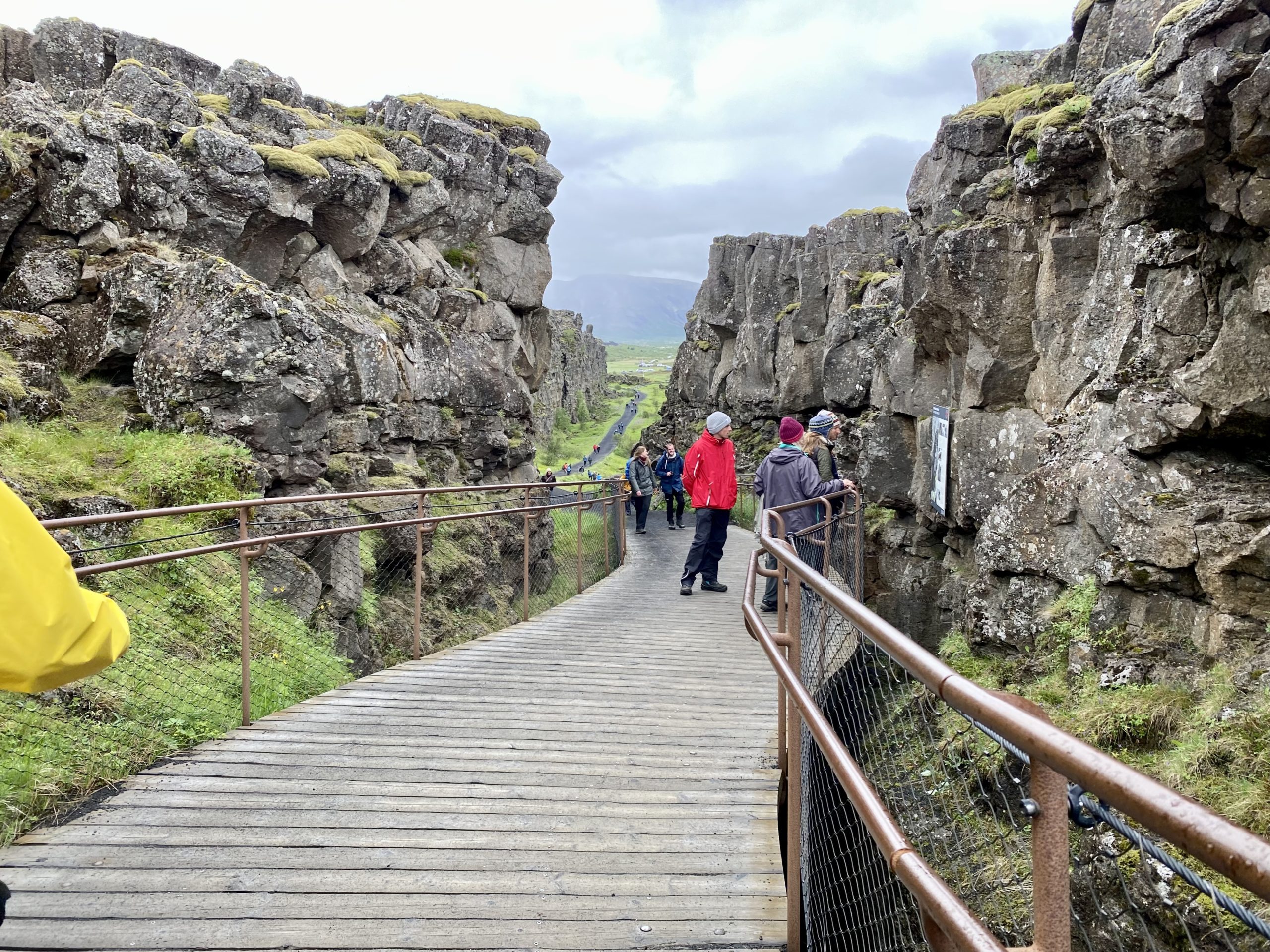 a group of people walking on a wooden walkway