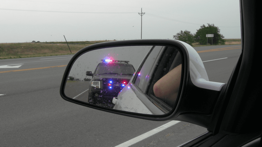 a rear view mirror of a car with lights on