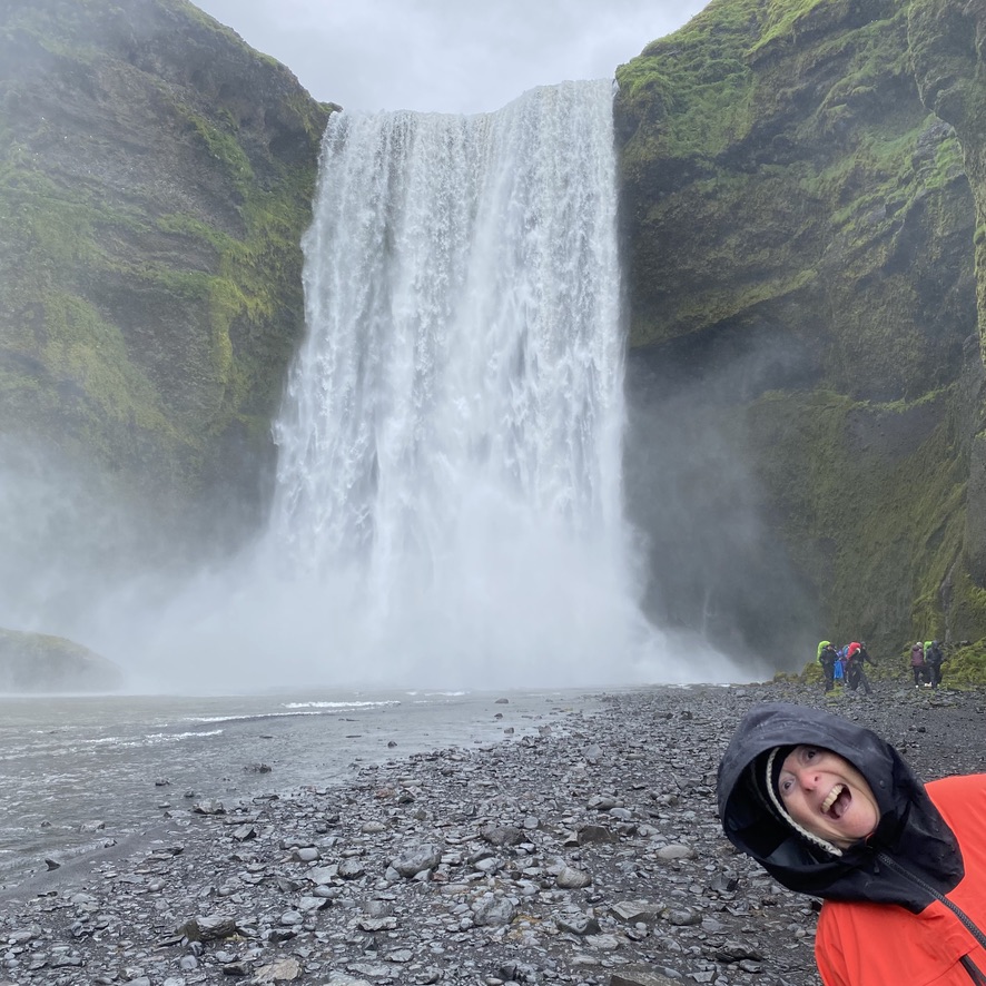 a person taking a selfie in front of a waterfall