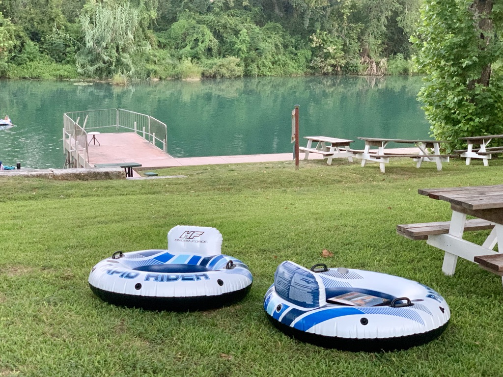 two rafts on grass next to a lake