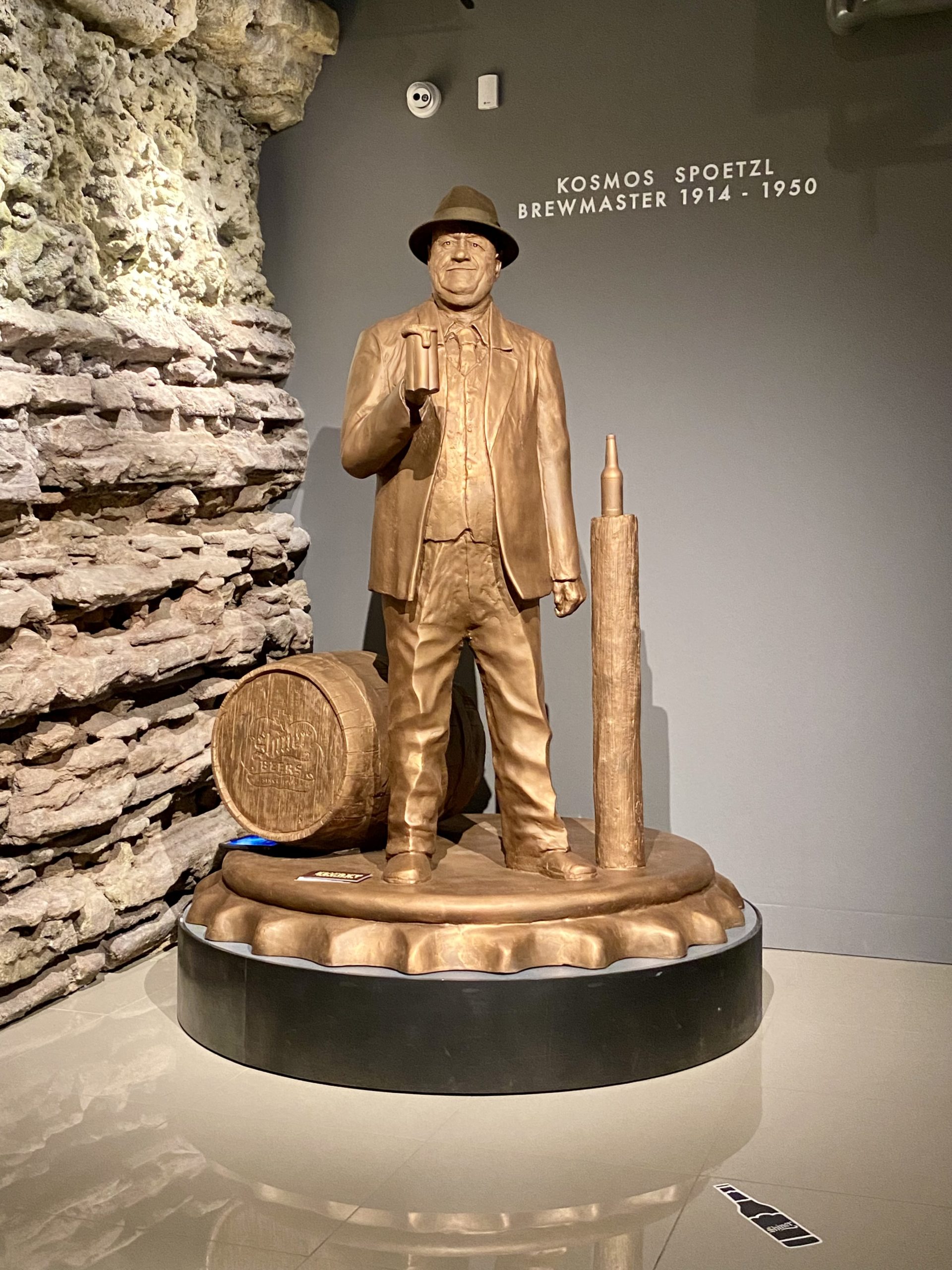 a statue of a man holding a barrel and a barrel
