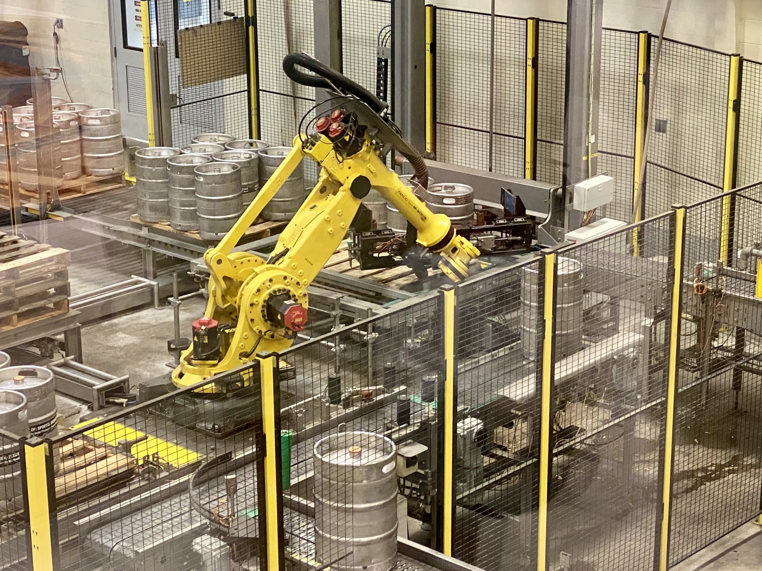 a yellow robot arm in a factory