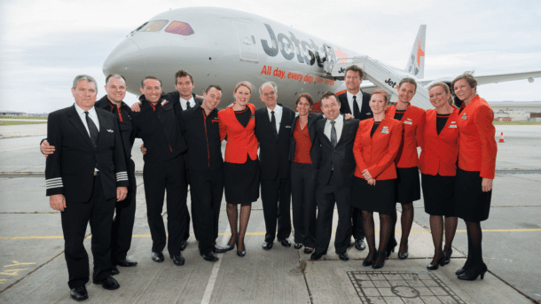 a group of people standing in front of a plane