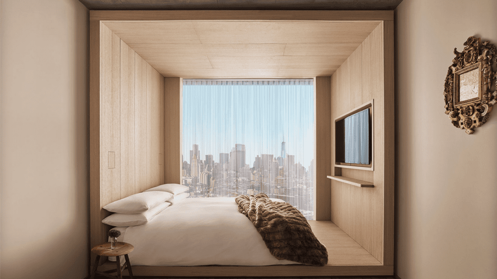 a bed with a large window and a city view