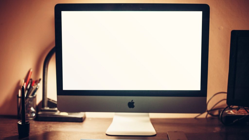 a computer monitor on a desk