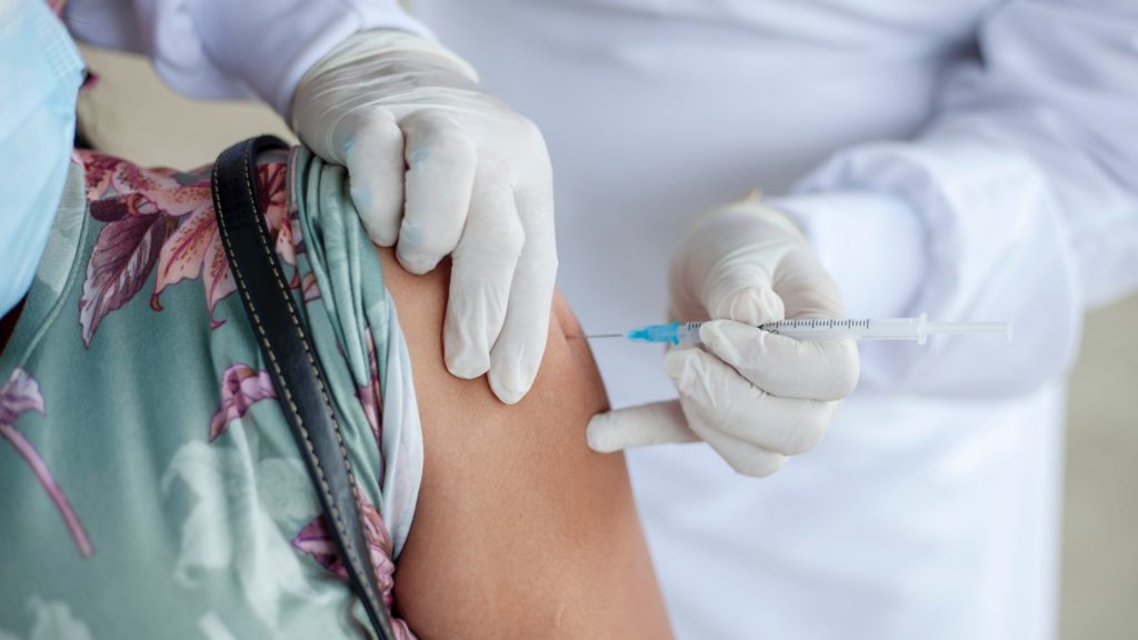 a person injecting a person's arm