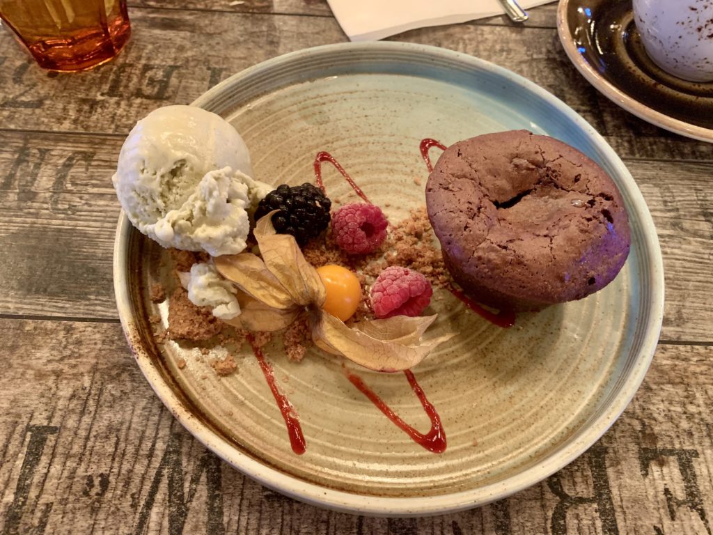 a plate of dessert with ice cream and fruit
