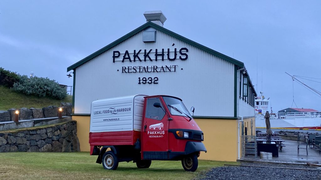 a red and white truck in front of a restaurant