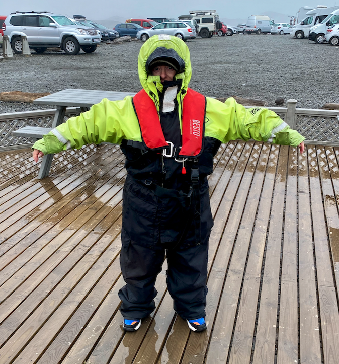 a person in a rain suit standing on a deck