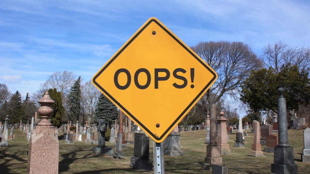 a yellow sign in a cemetery