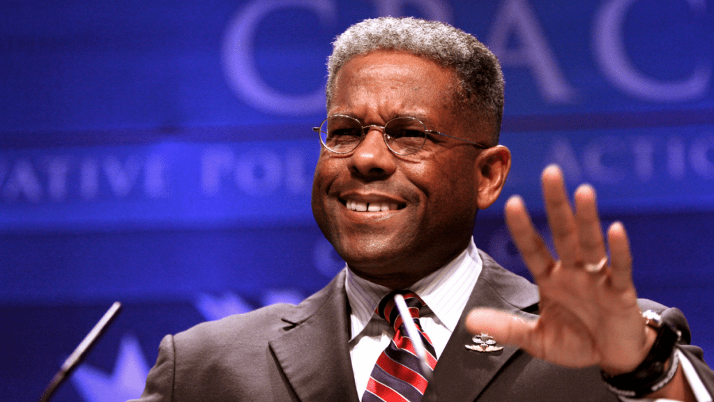 a man in a suit and tie waving