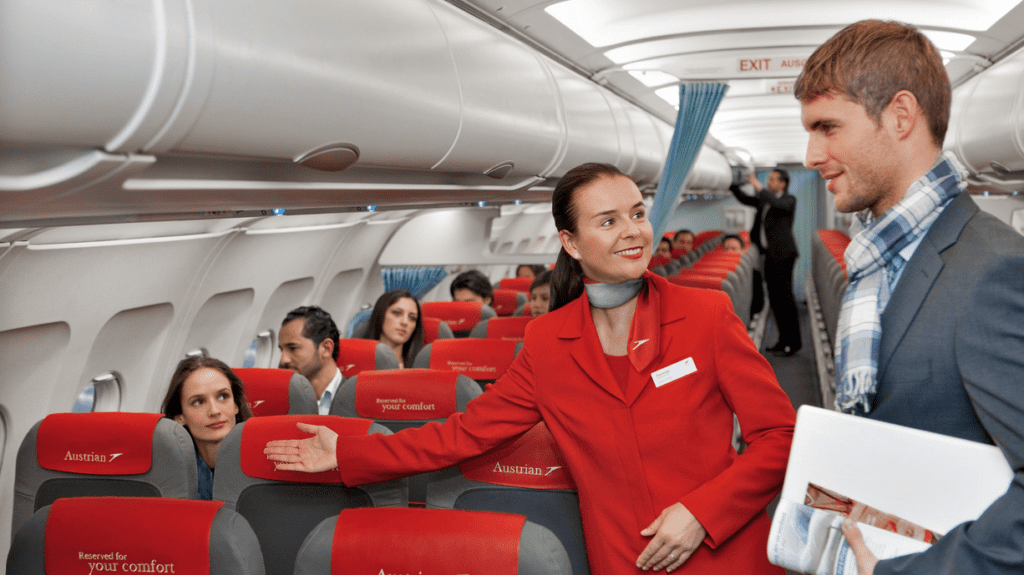 a woman in red coat standing in an airplane