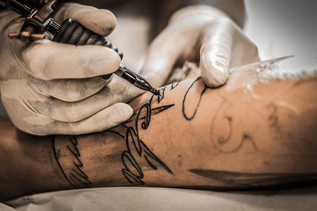 a person getting a tattoo on their arm