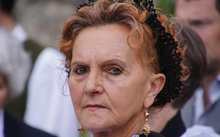 a woman with a black headband and earrings
