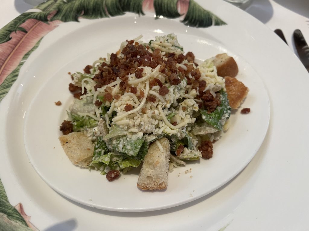 a plate of salad with croutons and cheese