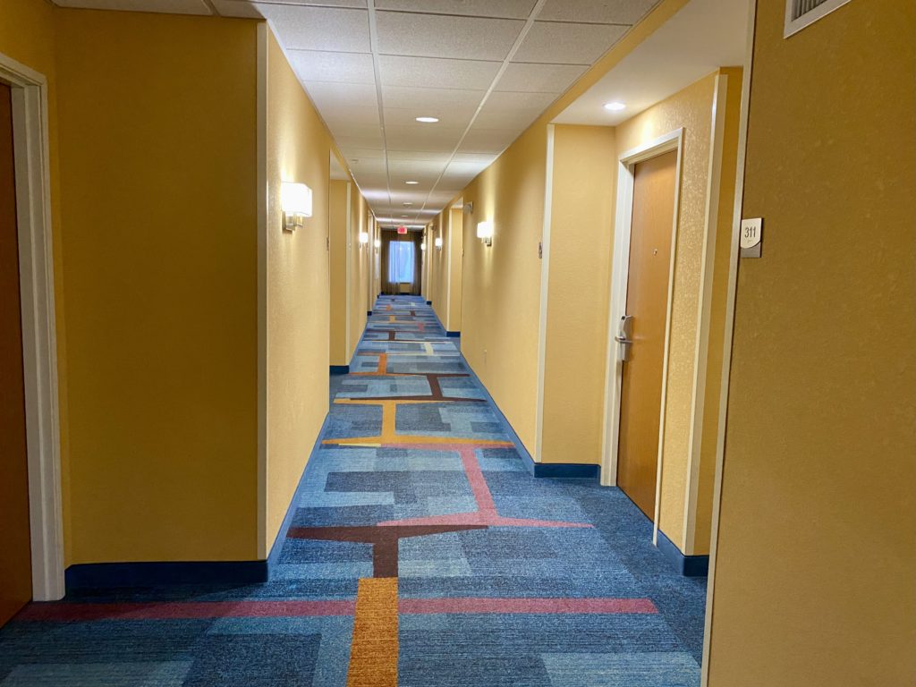 a hallway with a door and a carpeted floor