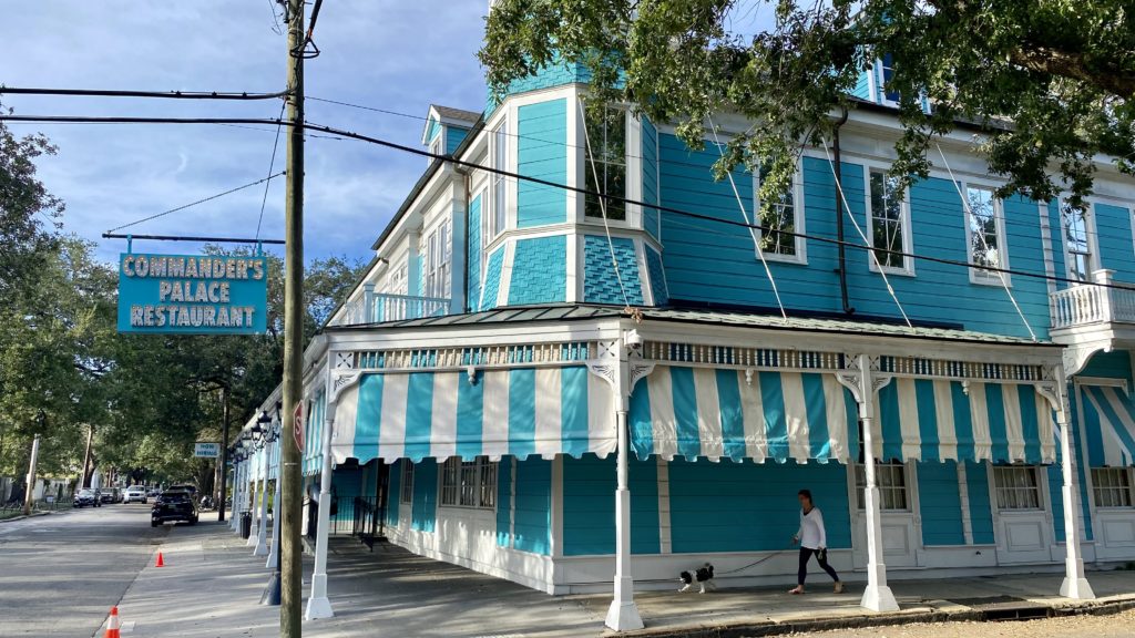 a blue and white striped building with a person walking a dog