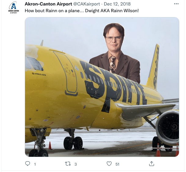 a man in a suit standing on a yellow airplane