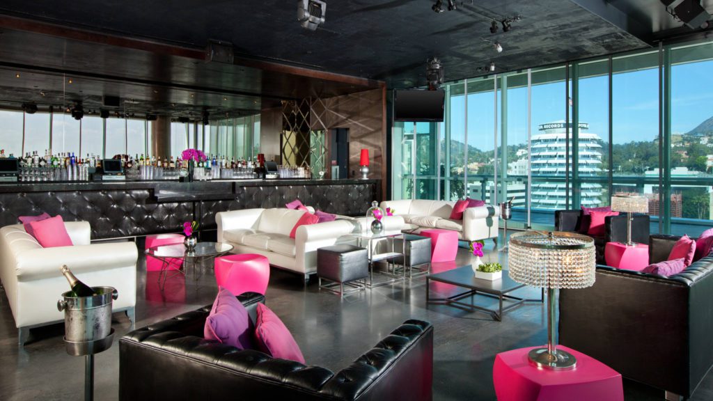 a room with a bar and a bar with a pink and white couches