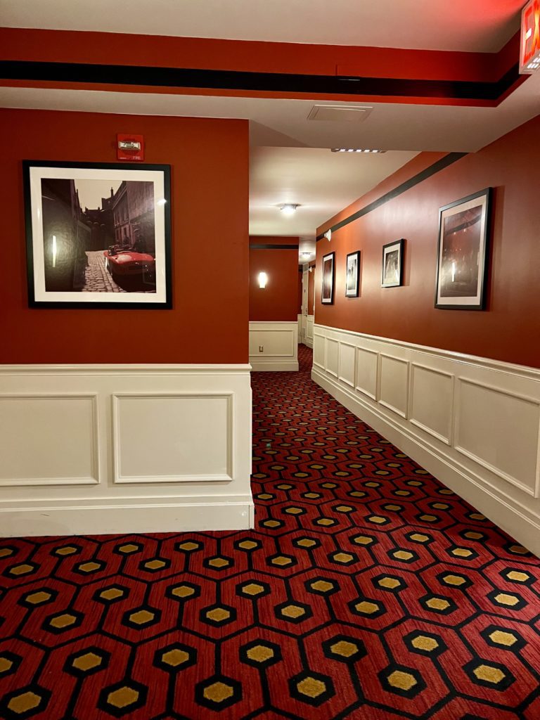 a hallway with red walls and a picture on the wall