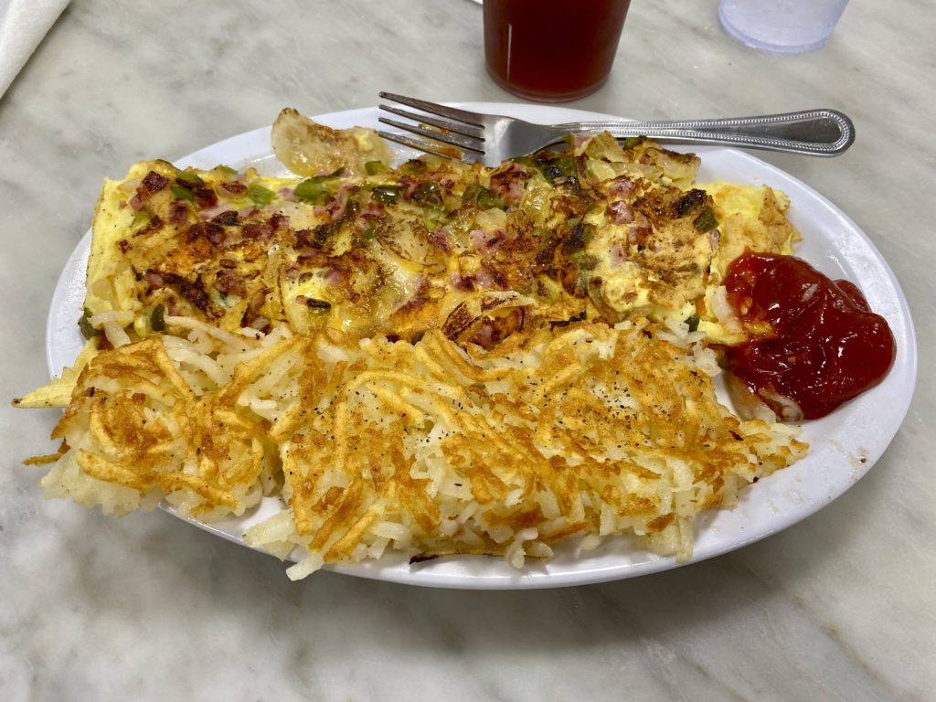 a plate of food with a fork and a glass of juice