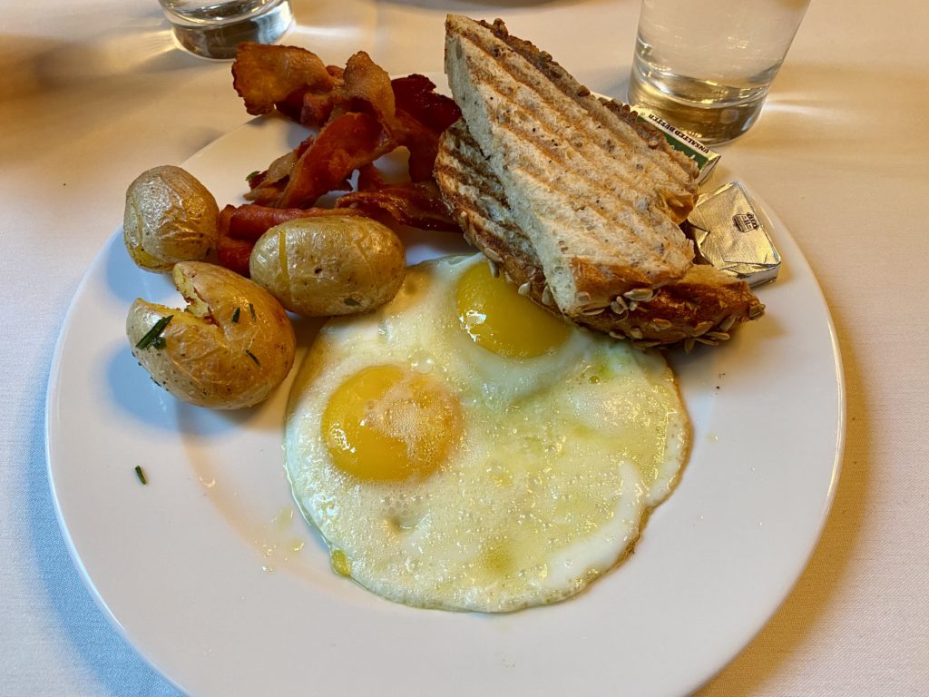 a plate of food with eggs potatoes and bacon