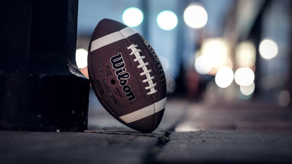 a football leaning against a pole