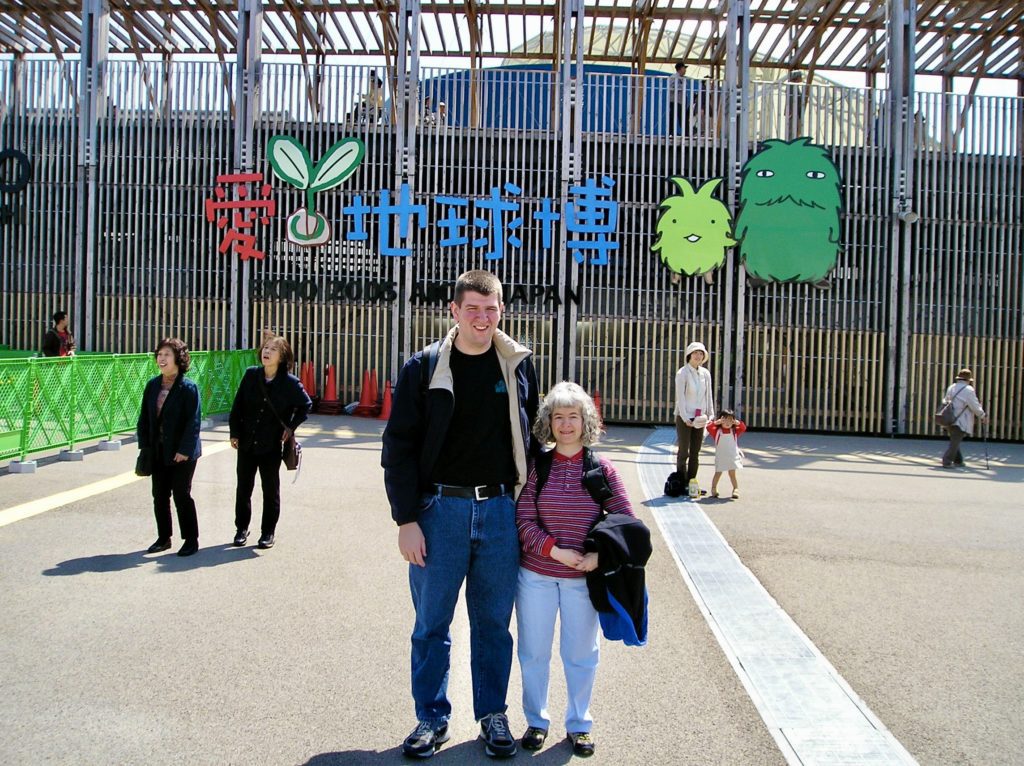 a man and woman standing in front of a metal structure