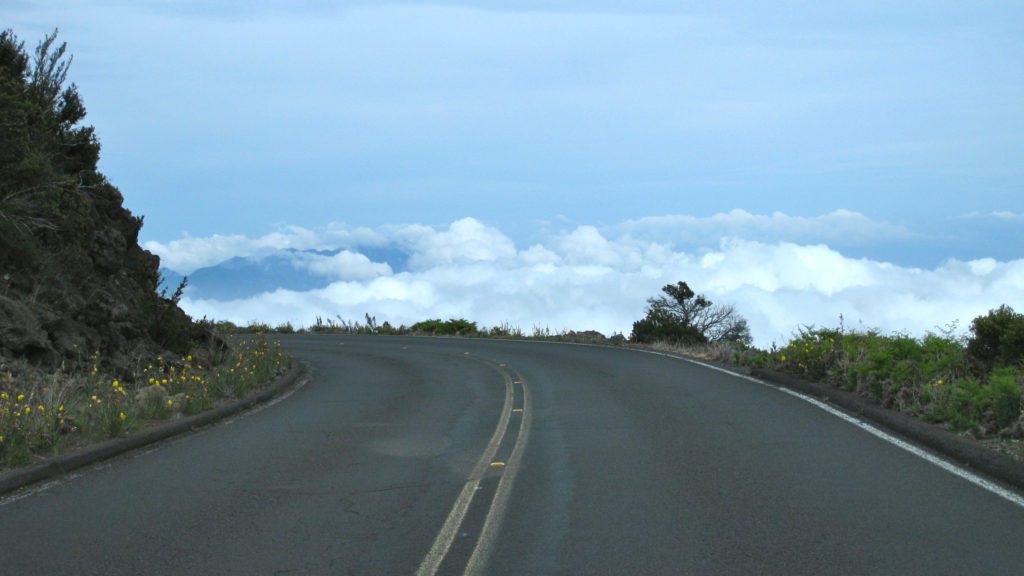a road with clouds in the background