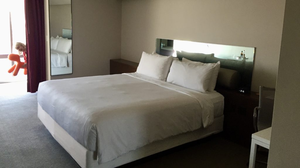 a bed with white sheets and pillows