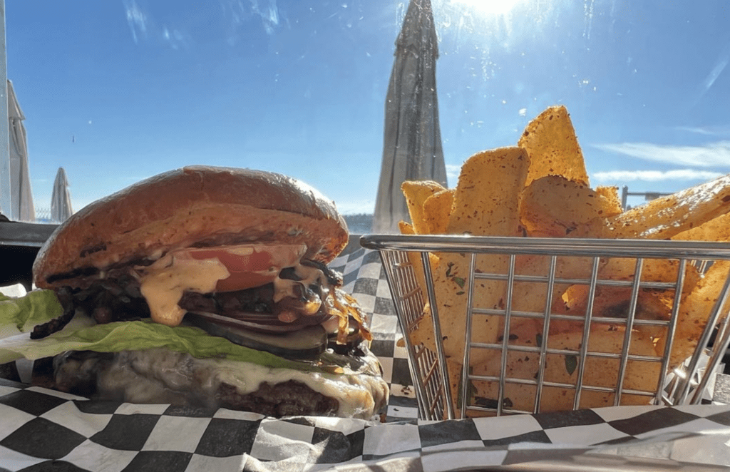 a burger and fries on a checkered tablecloth