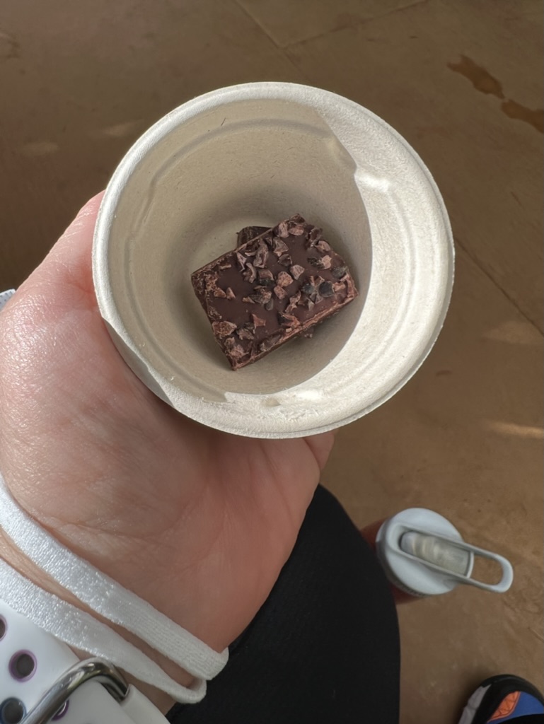 a hand holding a small cup of chocolate