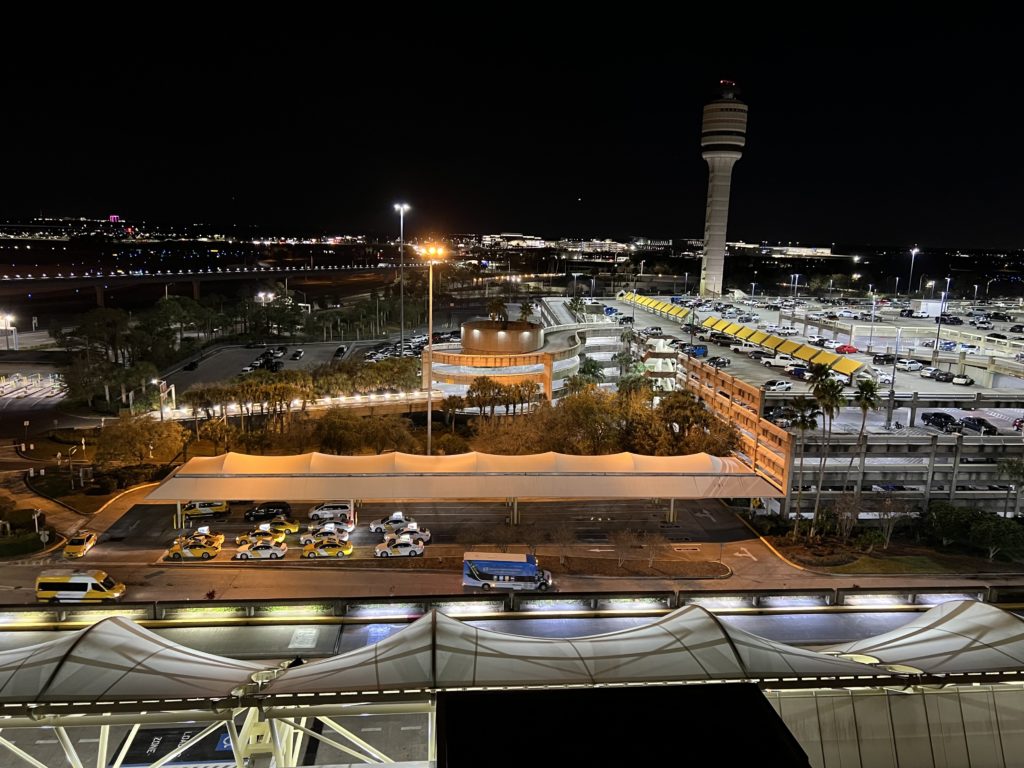 a parking lot with cars and a tower at night