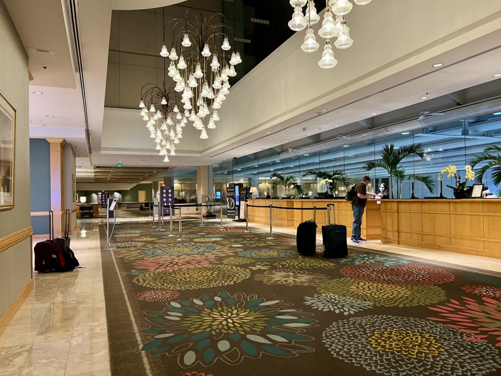 a hotel lobby with a large chandelier and luggage