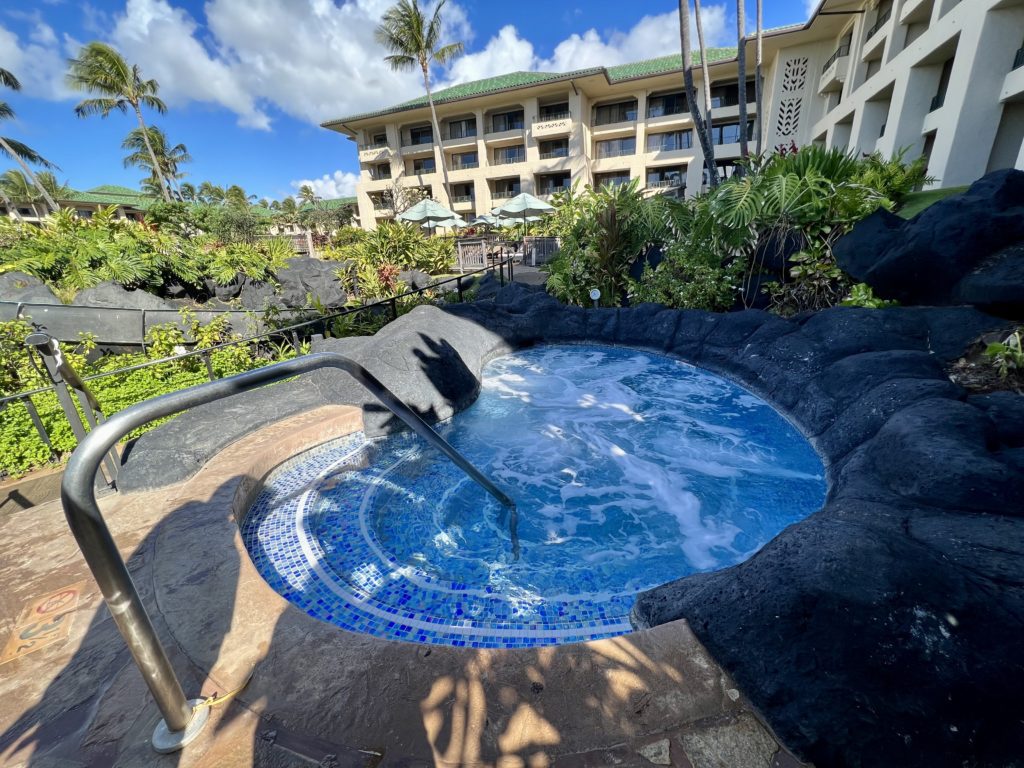 a hot tub with a railing in front of a hotel