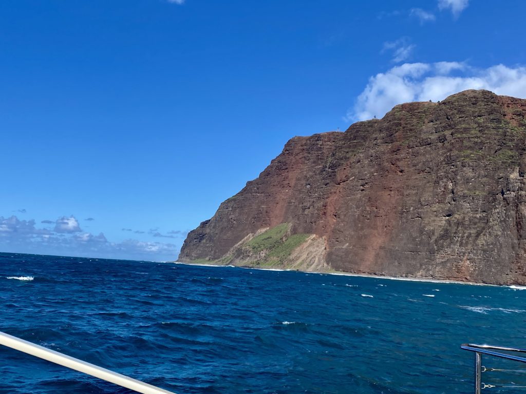 a body of water with a cliff in the distance